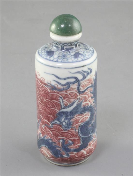 A Chinese underglaze blue and copper red dragon cylindrical snuff bottle, 19th century, height 8cm excl. stopper